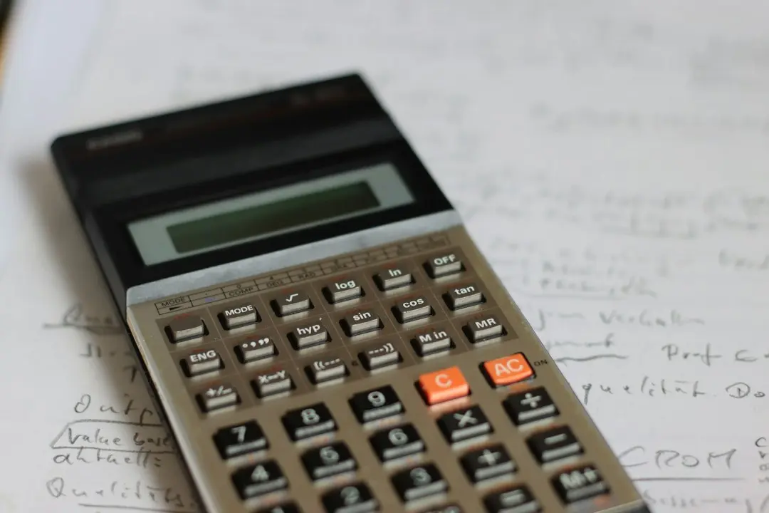 Une calculatrice posée sur des notes manuscrites pour comparer le prix des offres Xenon IPTV